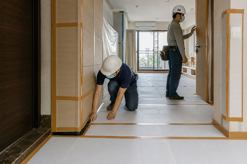 高雄住宅拆除前完成地面、門框與牆角保護，施工人員檢查室內保護動線