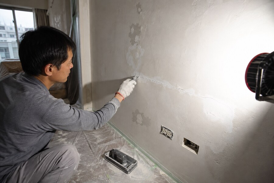 高雄住宅油漆施工前,師傅利用側光檢查牆面裂縫、舊漆鬆動與局部修補範圍